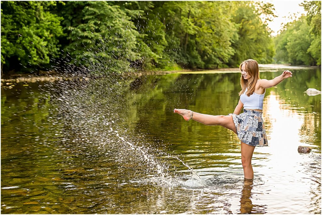 Brooke kicking water in a stream during Senior Photography session in Bridgewater VA