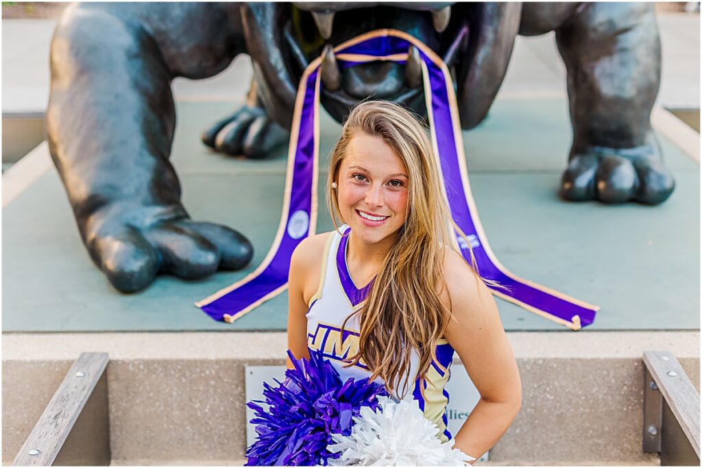 Savannah posing in her cheerleading outfit in front of Duke Dog during a Senior Photography session