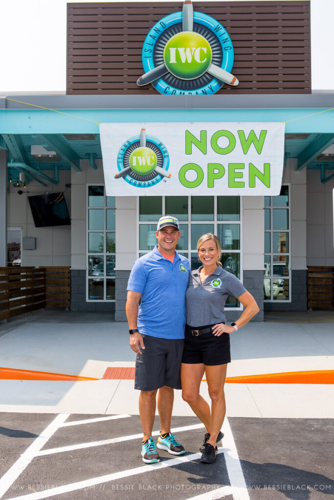 Corri and Travis Loan in front of their newly opened franchise of the Island Wing Company in Harrisonburg